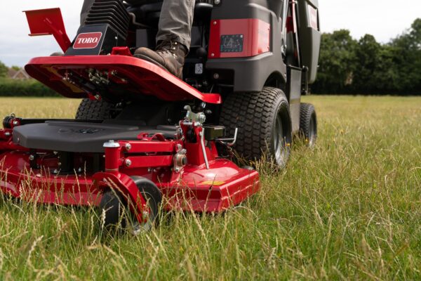 Close up of a Toro grounds mower cutting deck on long grass.