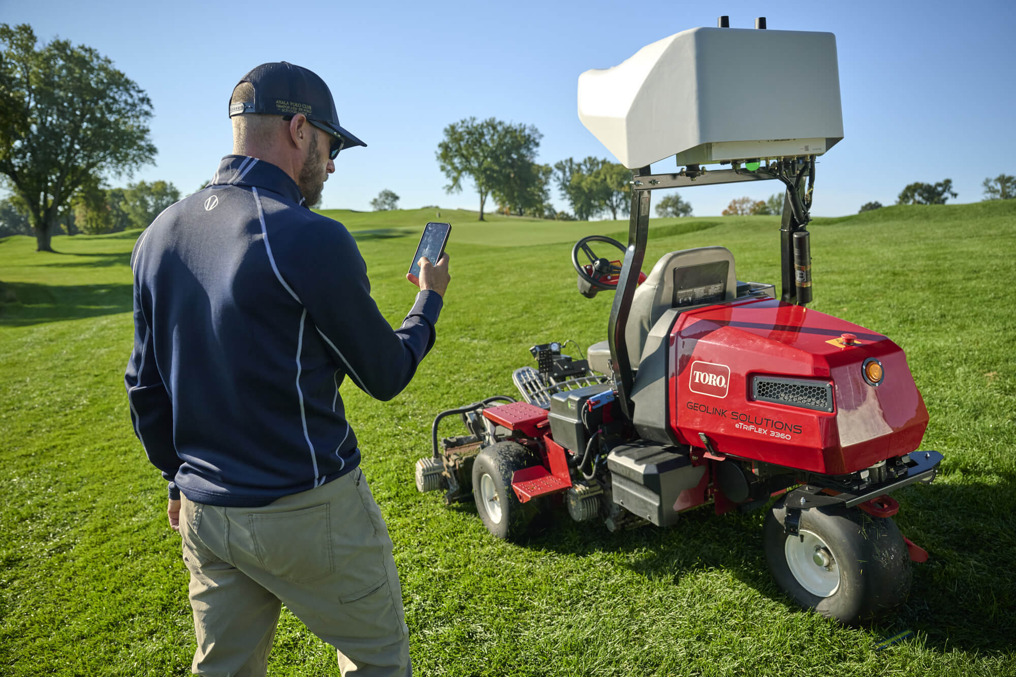 Greenkeeper controlling a Toro autonomous mower from their phone.