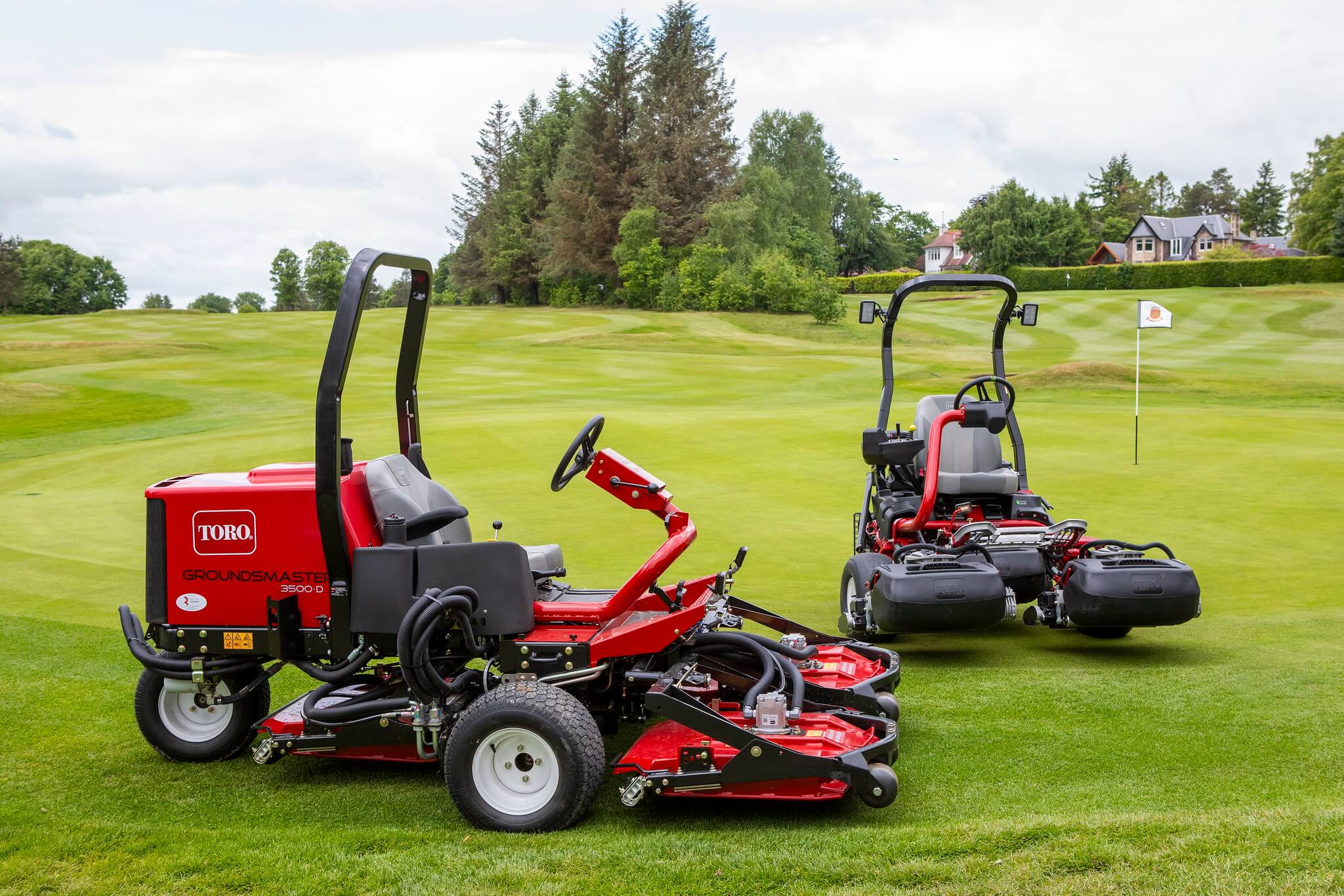 Two mowers, the Toro Greensmaster TriFlex 3420 hybrid and Groundsmaster 3500-D with Sidewinder on a golf course.