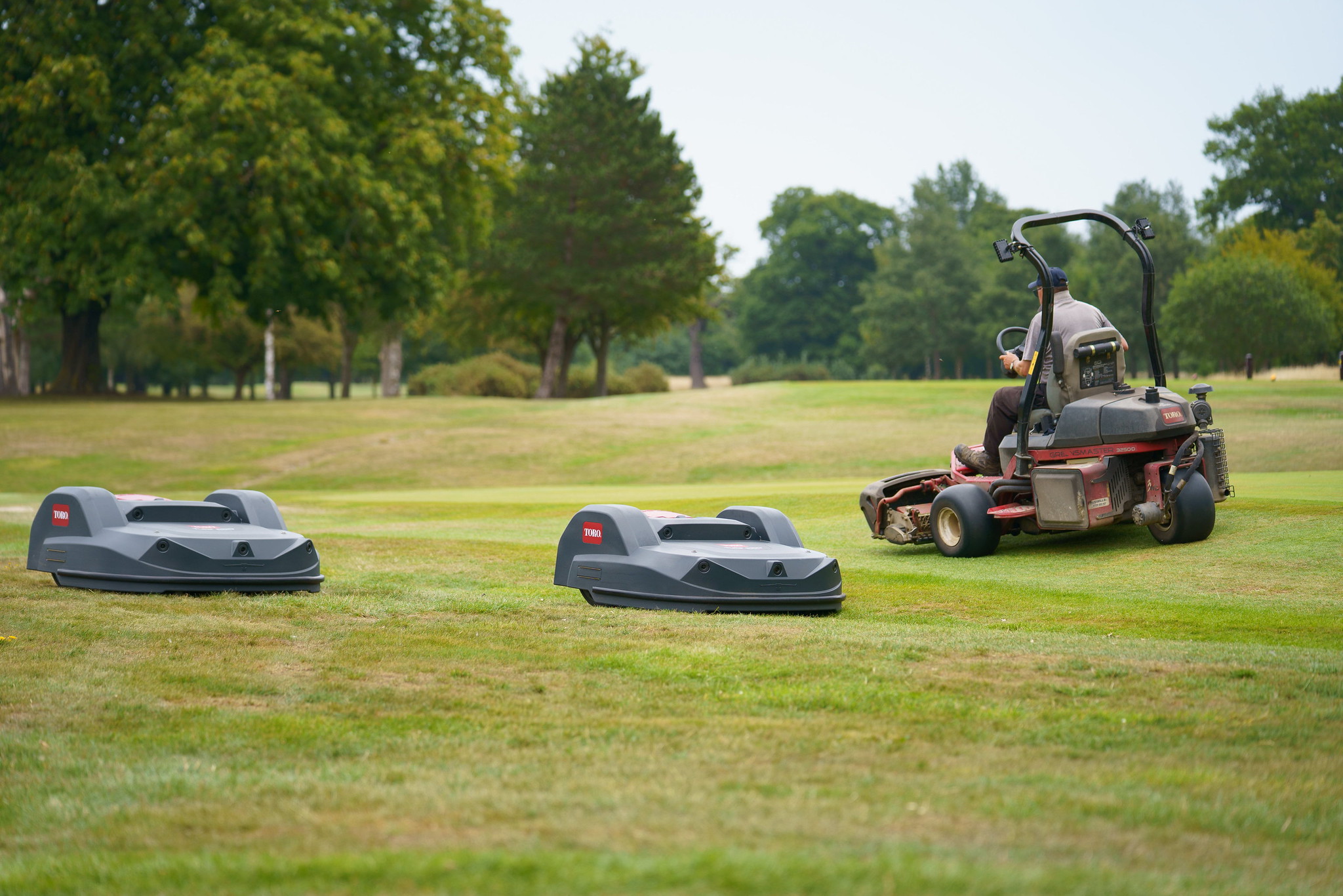 Two Toro Turf Pro mowers while a greenkeeper mows in the background