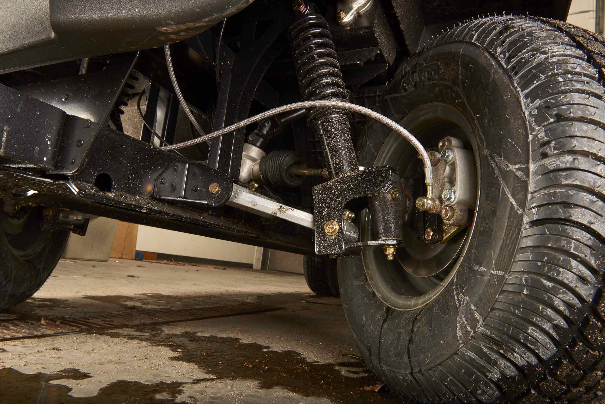 Close-up of Toro utility vehicle suspension and wheel assembly highlighting durable engineering for turf maintenance.