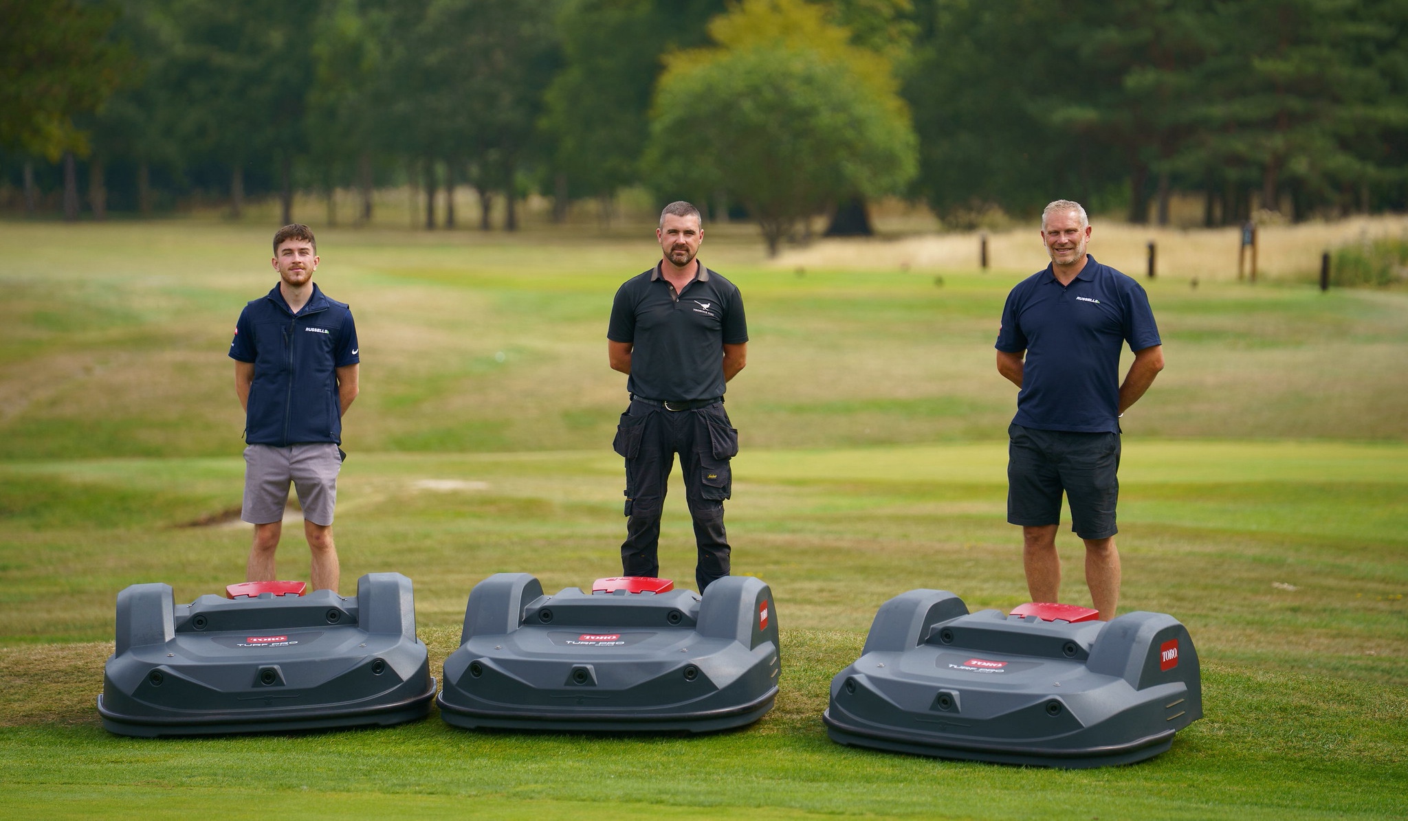 Thonock Park Course Manager Rob Acheson with Mason Sleight and Glen Sawyer, both from Toro dealer Russells Groundcare, standing behind three Toro Turf Pro 500 autonomous mowers