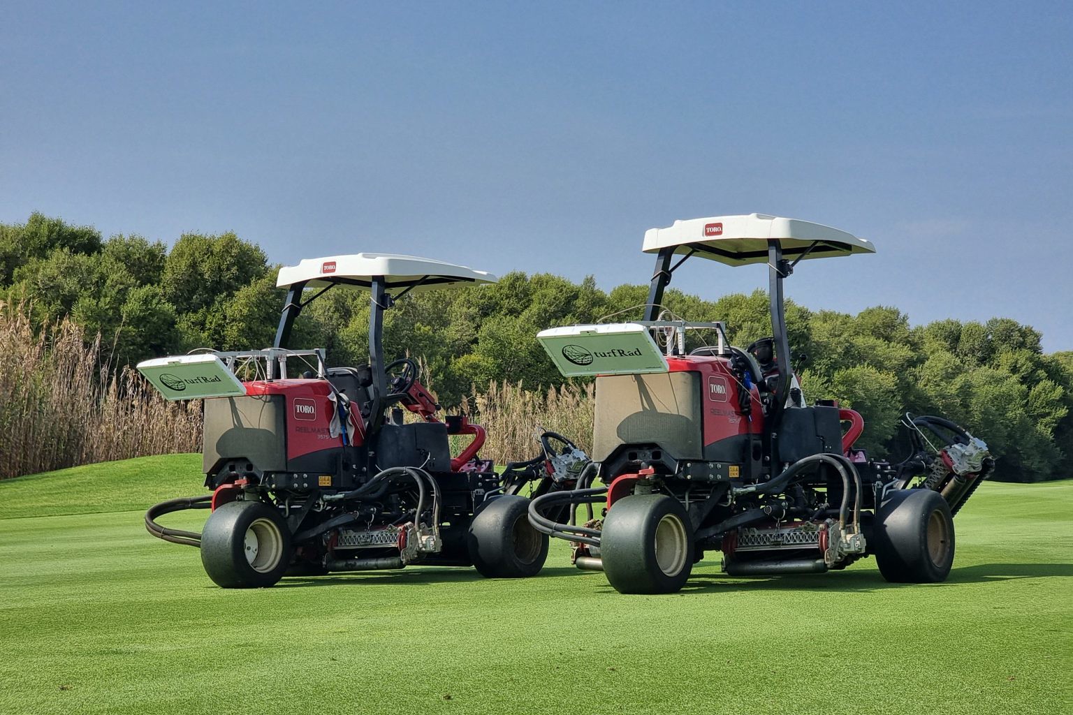 Two Toro mowers on a golf course with turfRad sensors attached