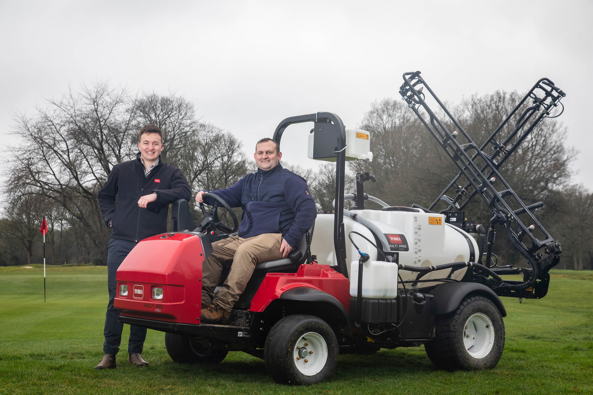 Huntercombe Golf Club course manager Grant Stewart (right) sits on a Toro Multi Pro sprayer while Liam Linehan from Reesink stands next to him.