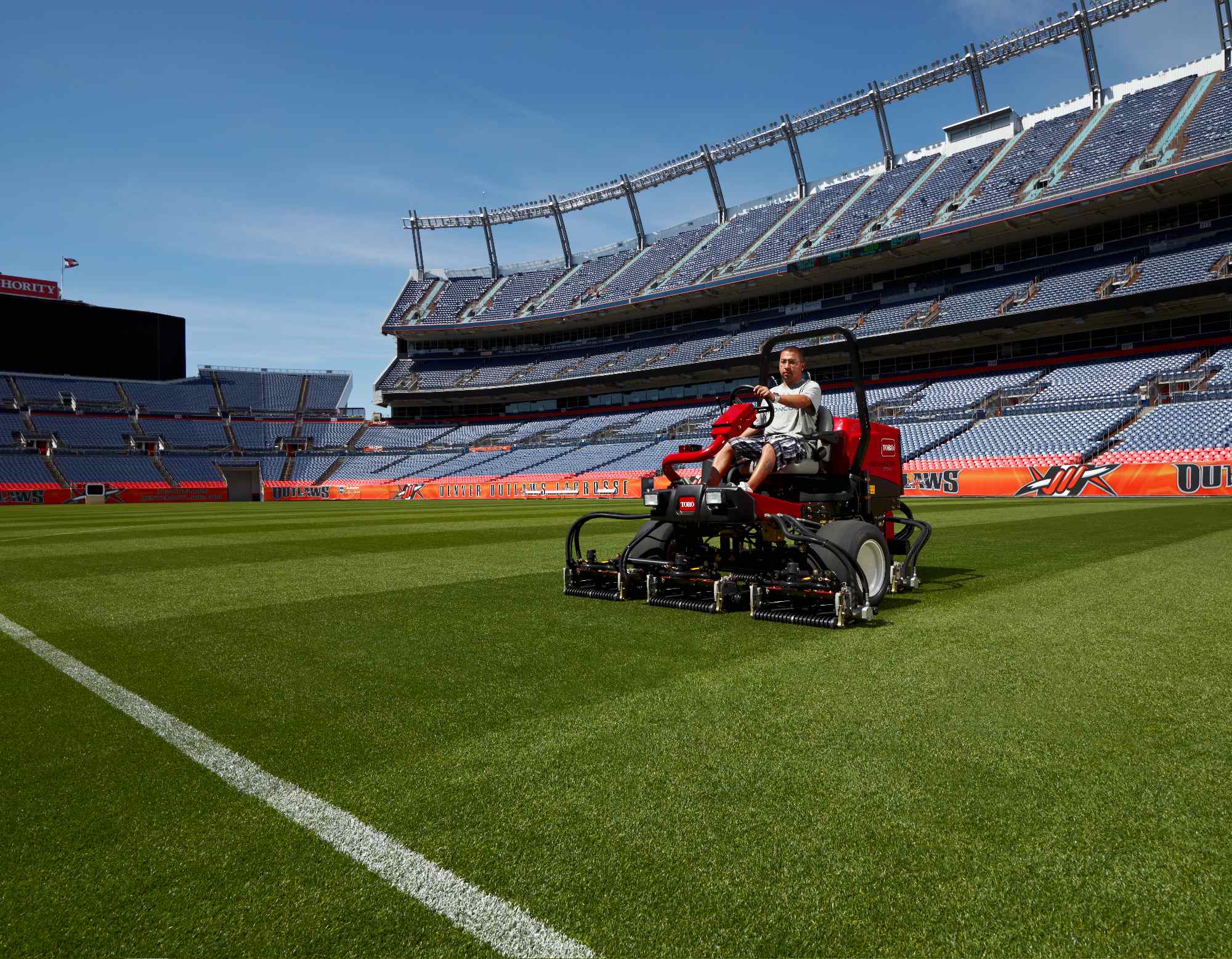 A Toro Reelmaster 3550-D mowing a football pitch inside a stadium.