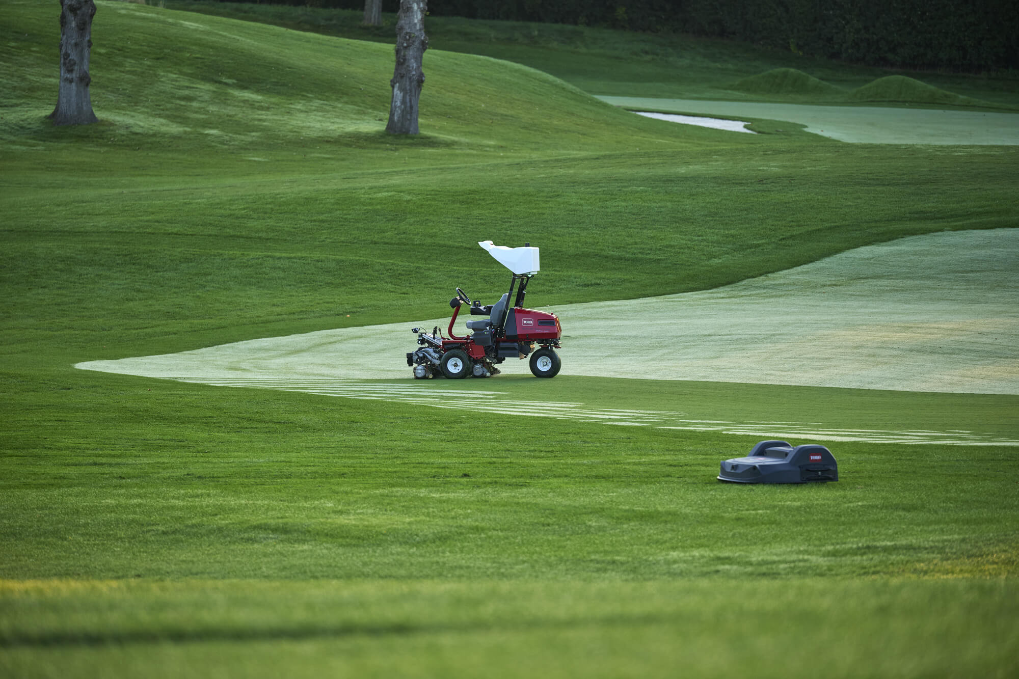 Toro Turf Pro 500 mower and autonomous Toro eTriFlex 3360 with GeoLink Mow mowing a golf course together.