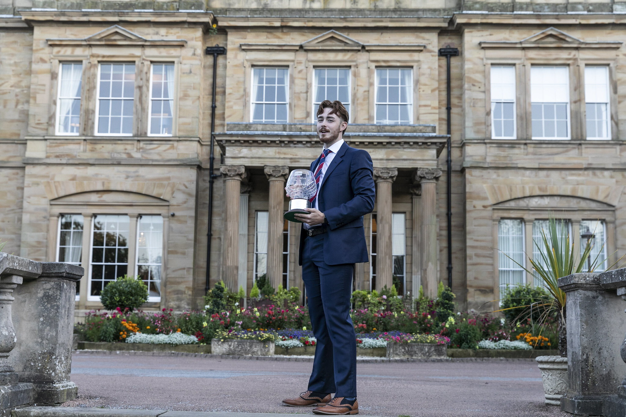 Daniel Parker, Young Student Greenkeeper of the Year 2024, holding his trophy outside the venue.