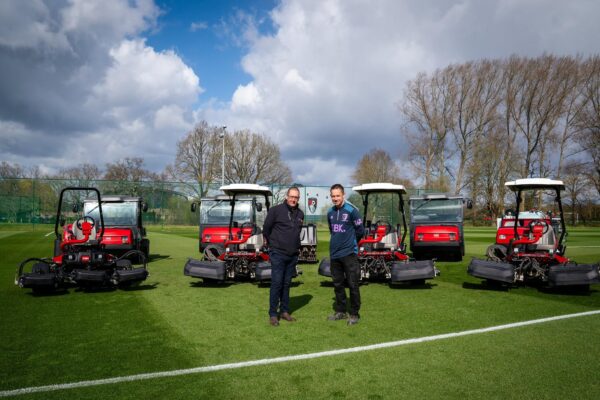 Reesink's Mark Winder and AFC Bournemouth's Ian Lucas stand in front of a fleet of Toro machinery.