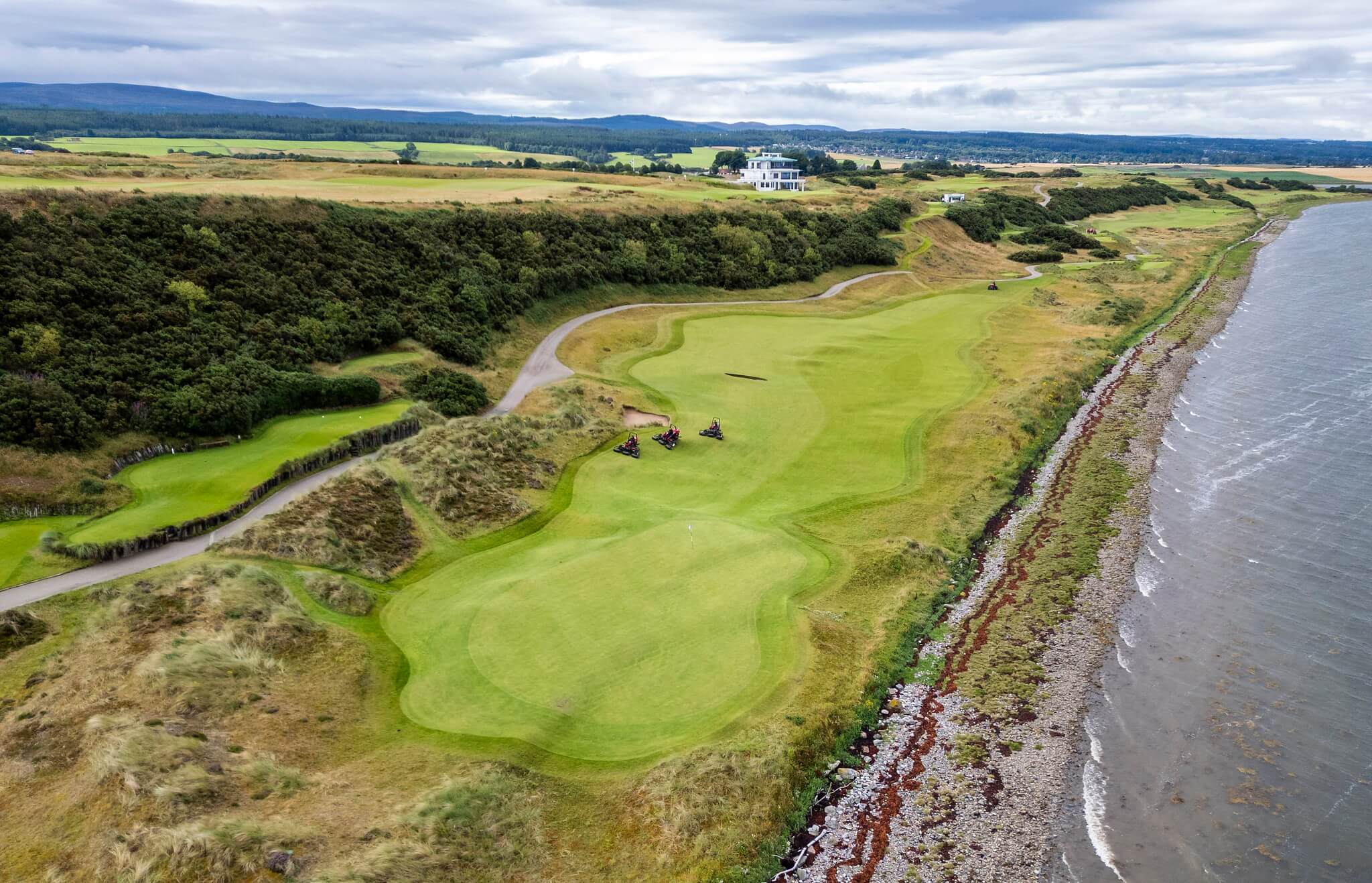 An aerial view of Toro mowers working in unison on a links golf course.