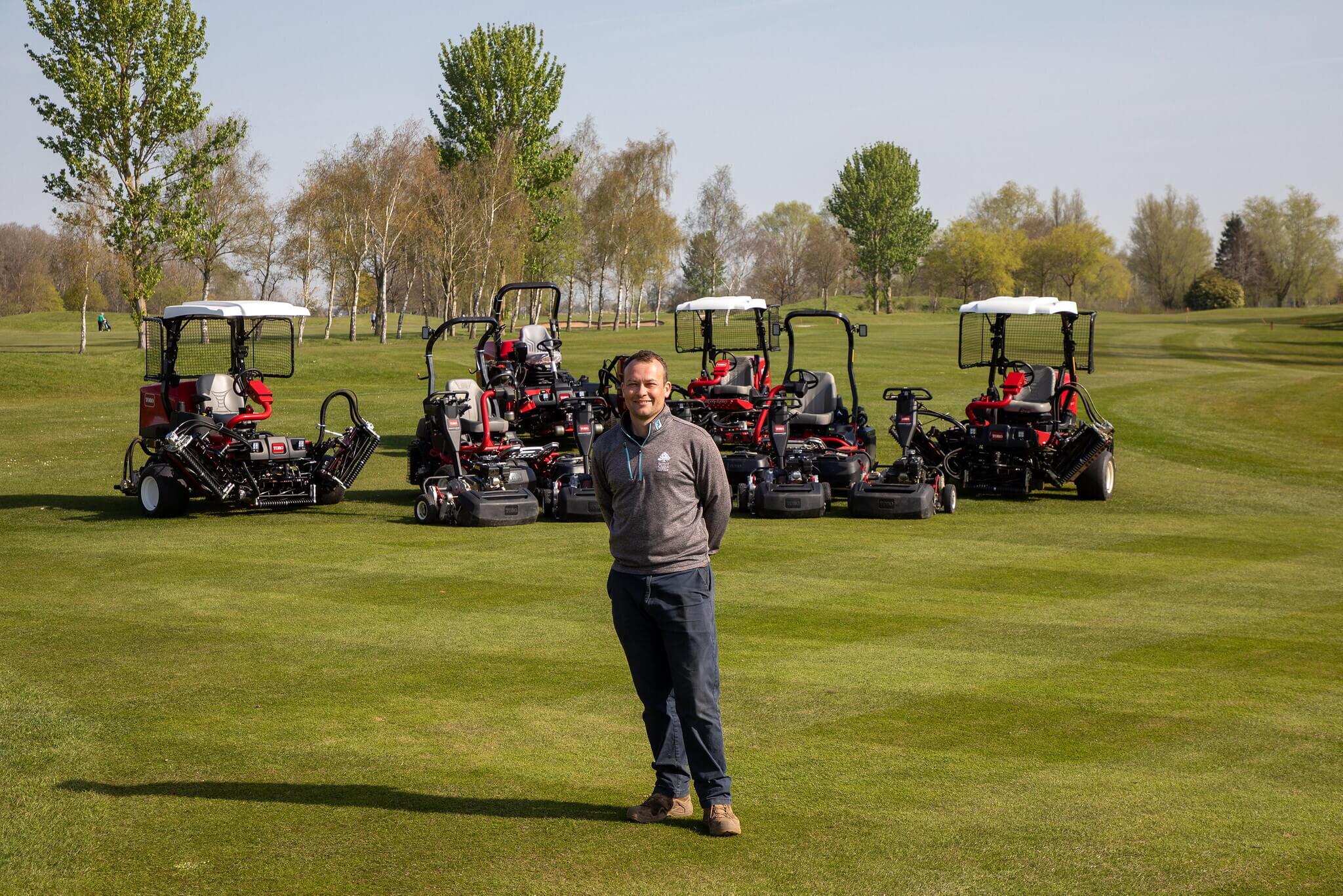 The course manager at Stratford Oaks standing in front of a new fleet of Toro mowers.