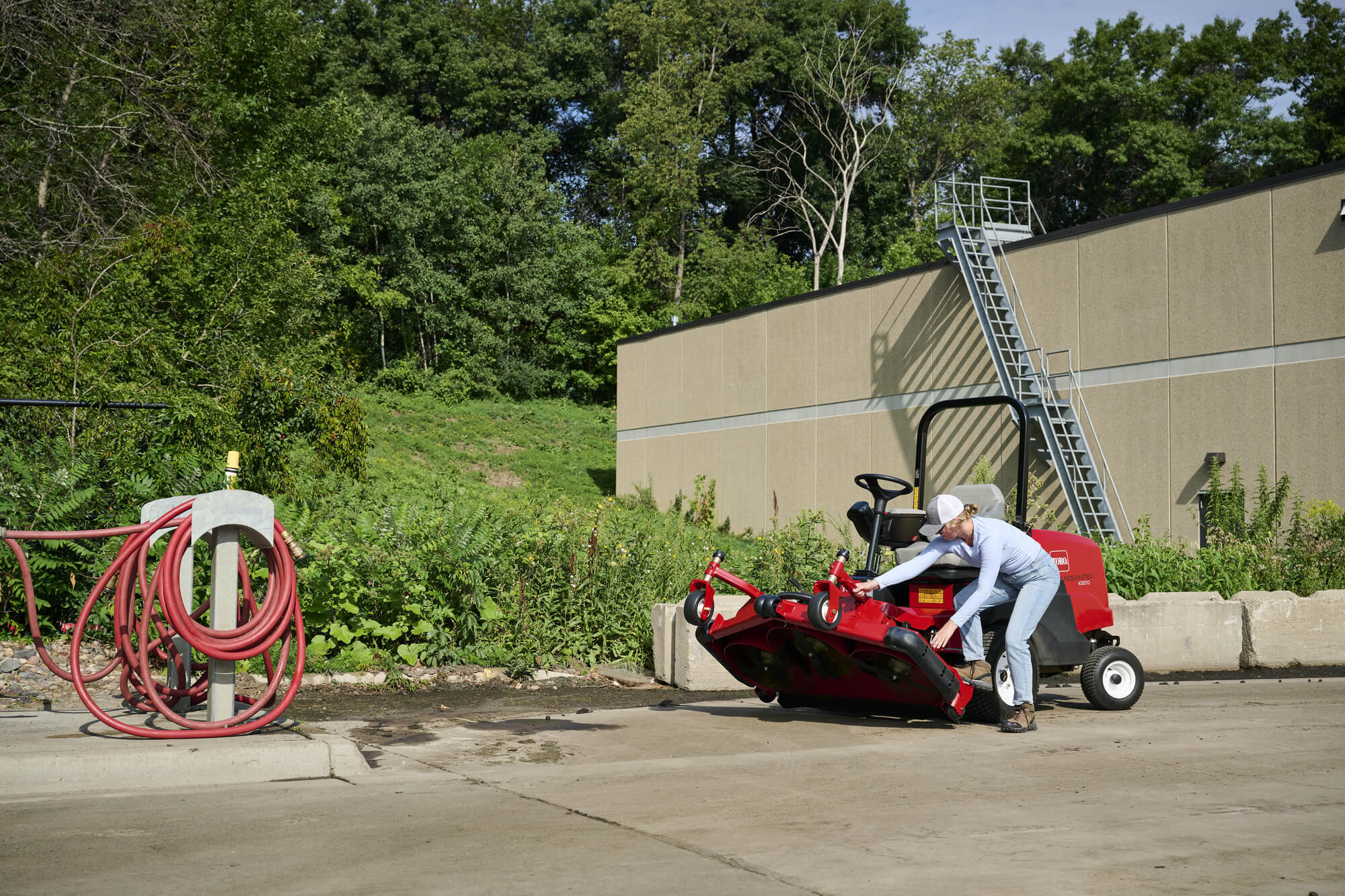 A Toro Groundsmaster deck being manoeuvred after a wash down.