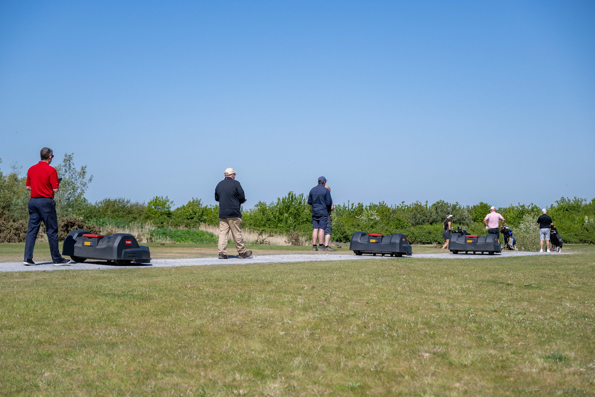 A fleet of Toro autonomous mowers travelling along a path.
