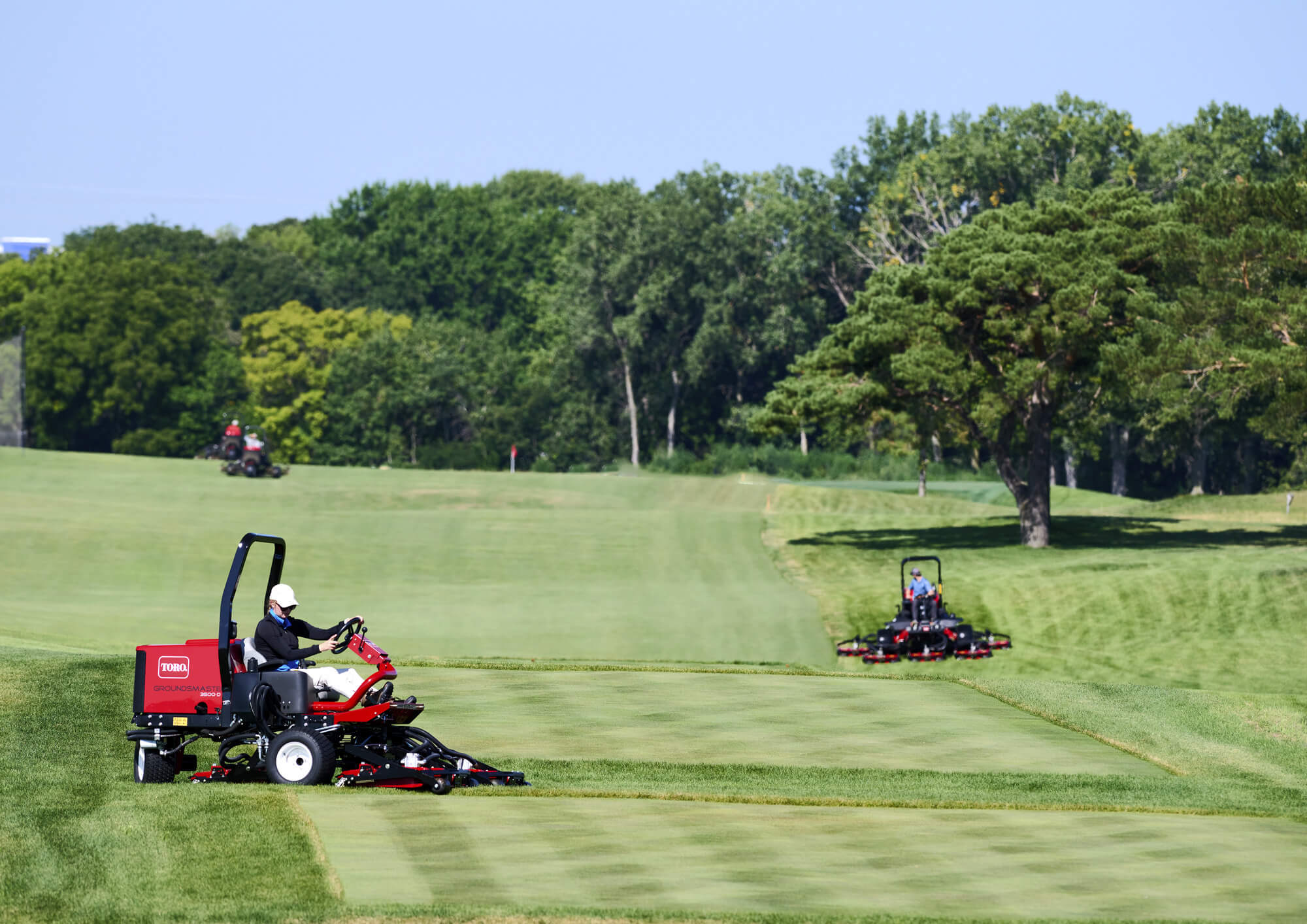 A Toro mower mowing a golf course with a diamond cut.