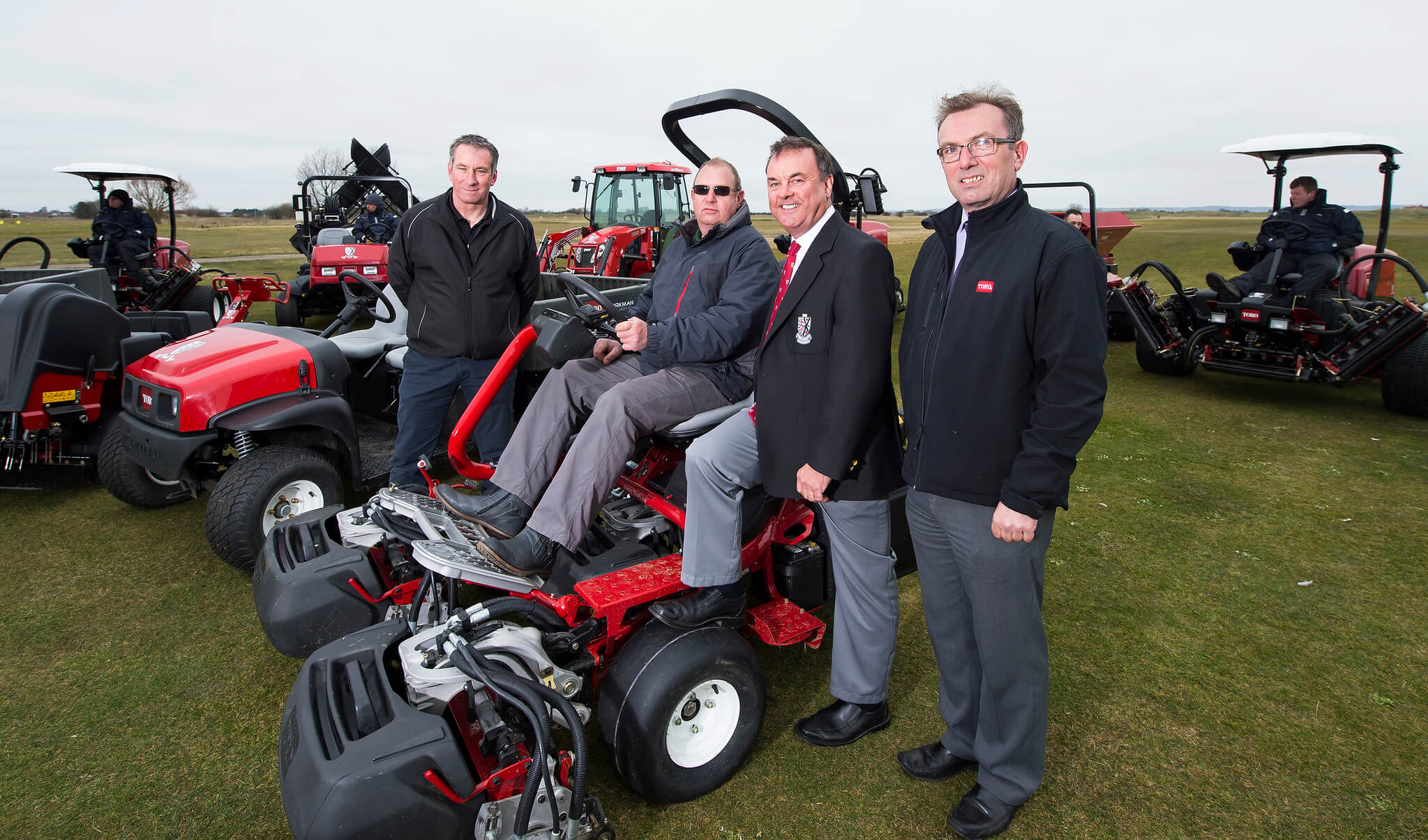 Reeink reps stood next to Littlestone Golf Club greenkeeper sitting on a Toro mower.