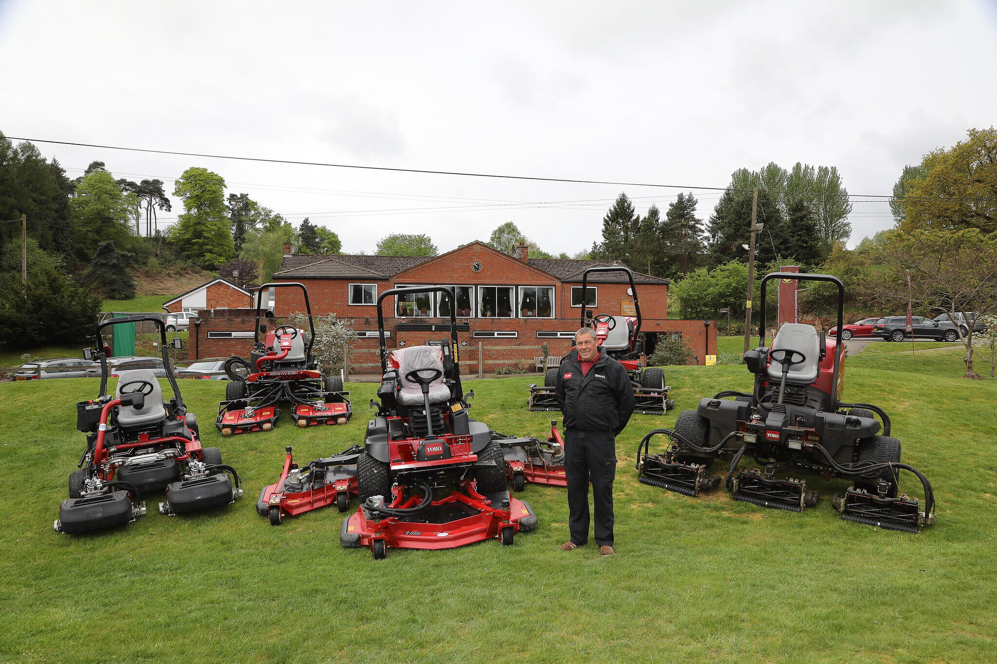 A fleet of Toro machinery in front of the clubhouse at Bridgnorth Golf Club.