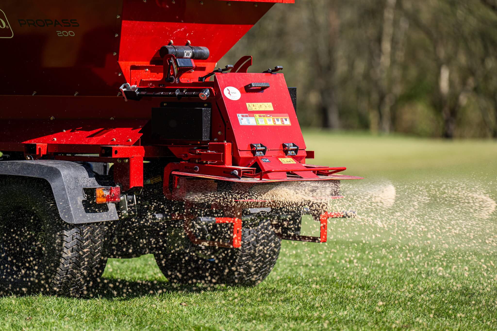 A Toro topdresser spreading sand.