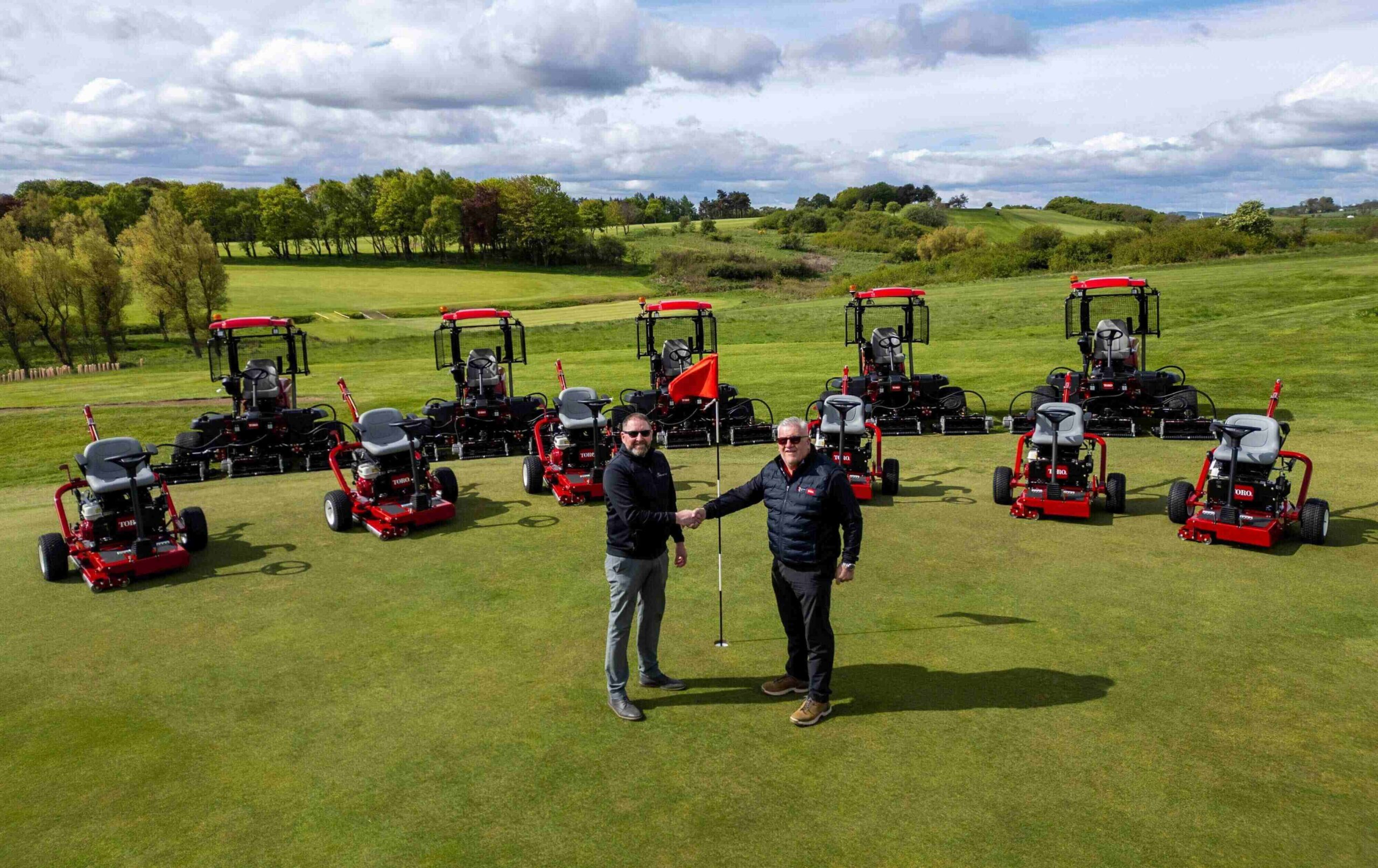 Fife Golf Trust's manager and one Reesink rep stand in front of eleven Toro mowers