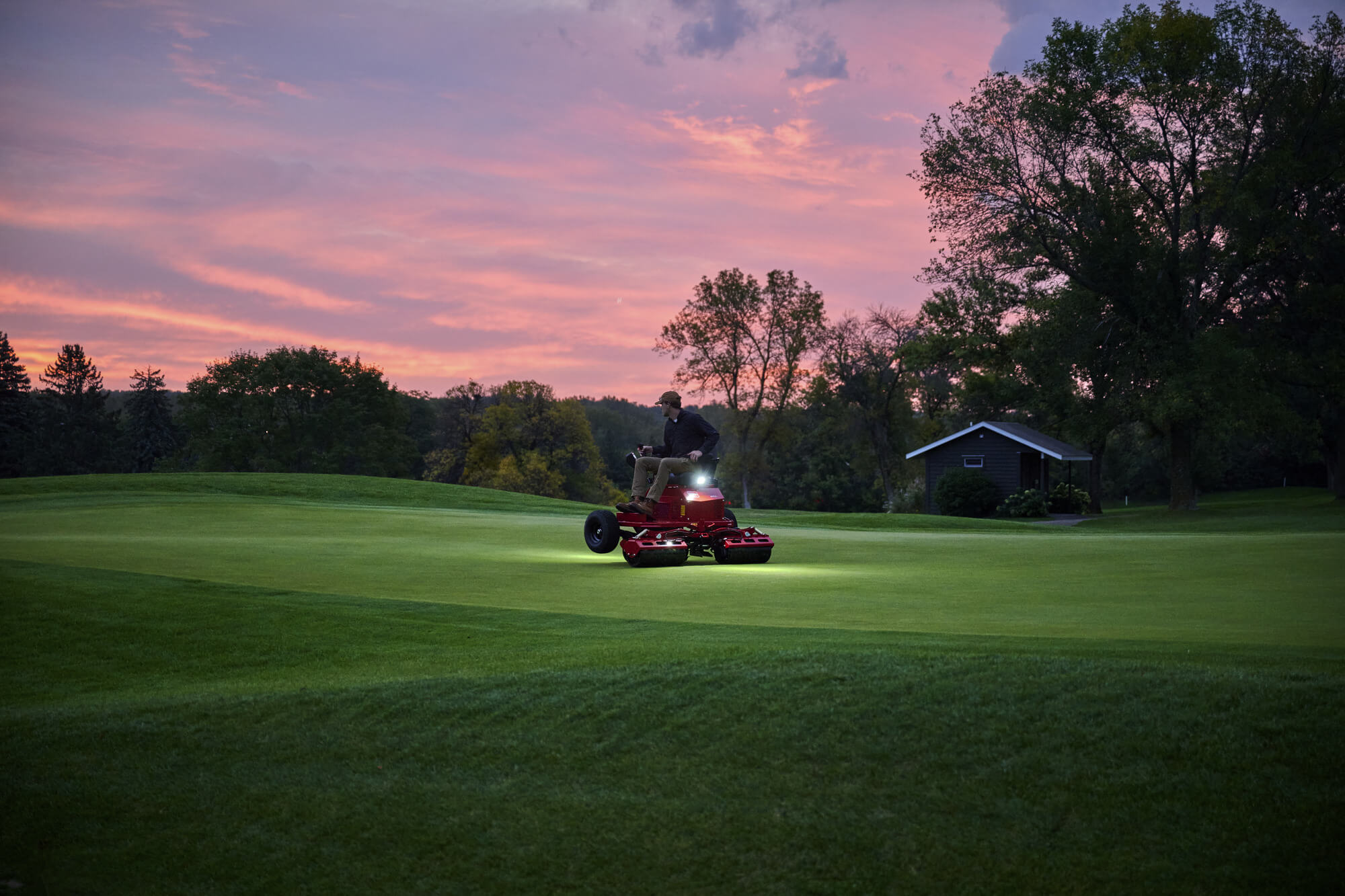 A Toro GreensPro e1700 all-electric greens roller on the golf course at dusk.