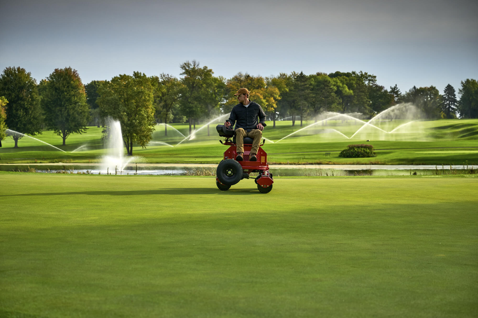 A Toro GreensPro e1700 all-electric greens roller rolling a golf green.