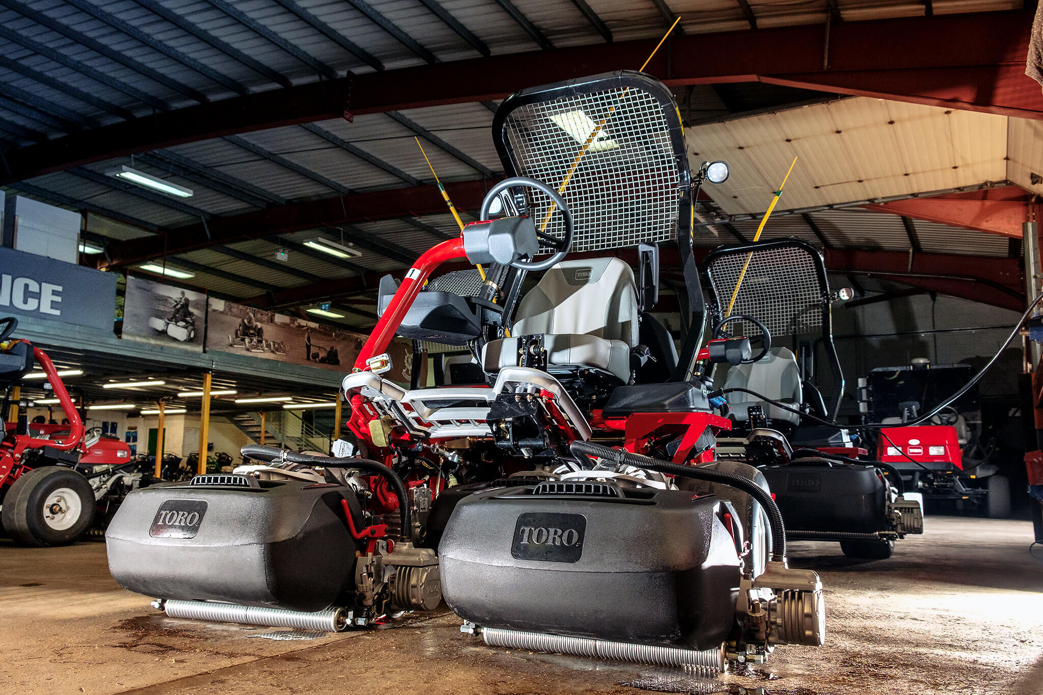 A Toro Greensmaster eTriFlex 3370 all-electric ride-on cylinder mower in the workshop.