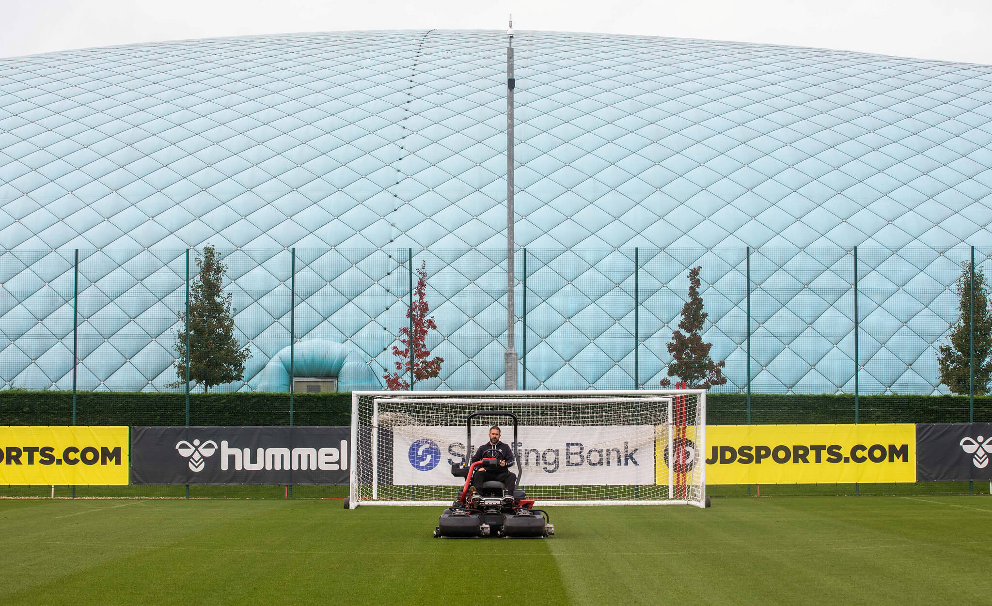 A Toro Greensmaster eTriFlex 3370 all-electric ride-on cylinder mower mowing a football pitch at Southampton FC.