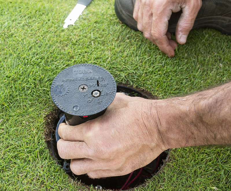 A Toro irrigation sprinkler head opened from the top for maintenance.