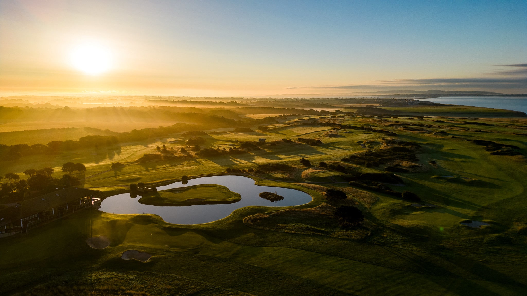 An aerial shot of Barton-on-Sea golf club, with a large water hazard lake being the focal point.