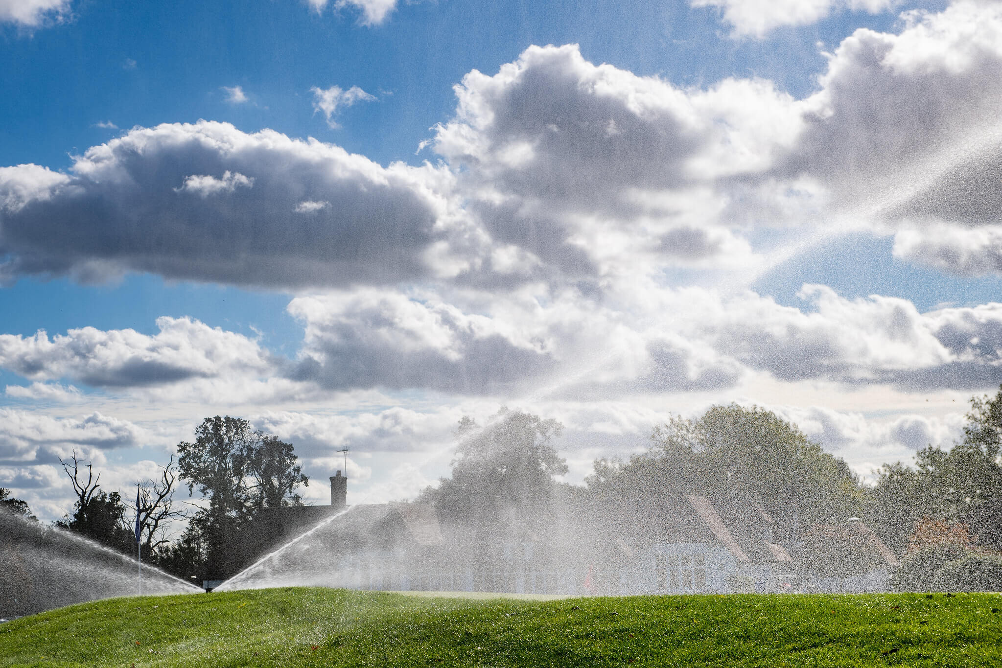 Toro Irrigation sprinklers spraying water over a golf fairway. 
