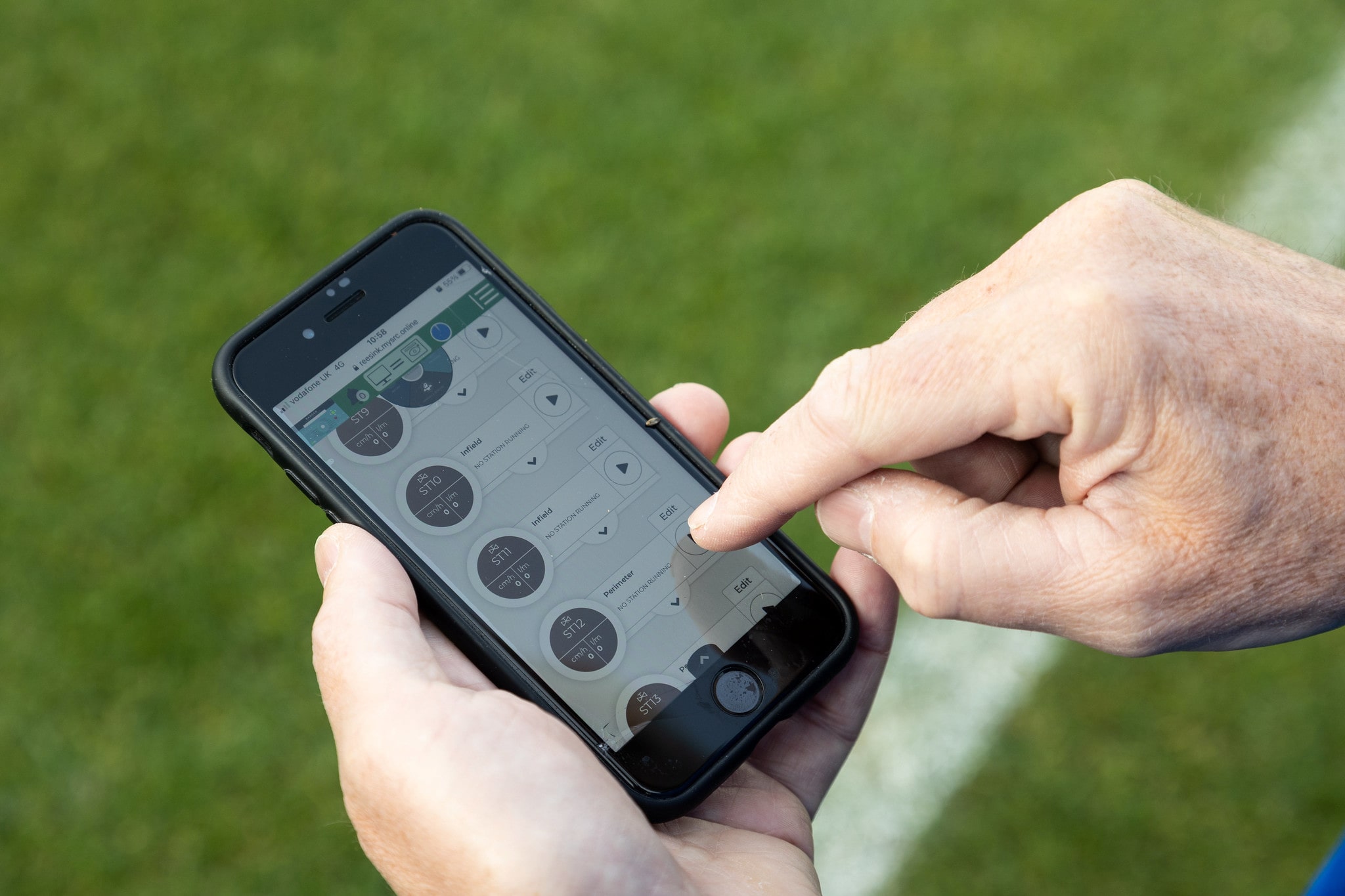 A close up of a mobile phone, the user is accessing the SRC irrigation controller through an app, adjusting infield sprinklers.