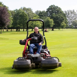 Terry Wharton, head greenkeeper at Haydock Park Golf Club, sitting on the Greensmaster TriFlex Hybrid 3420 mower.