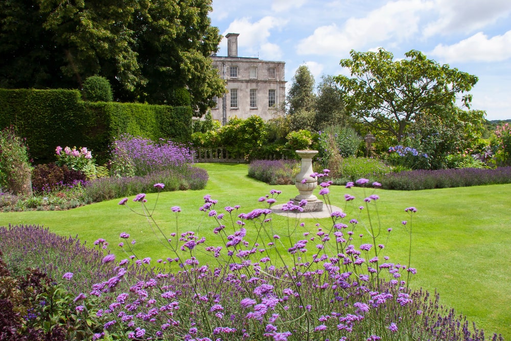 A large national trust English garden with well kept grass.